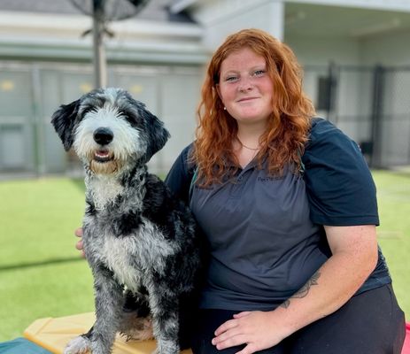 a woman sitting on a bench with a dog