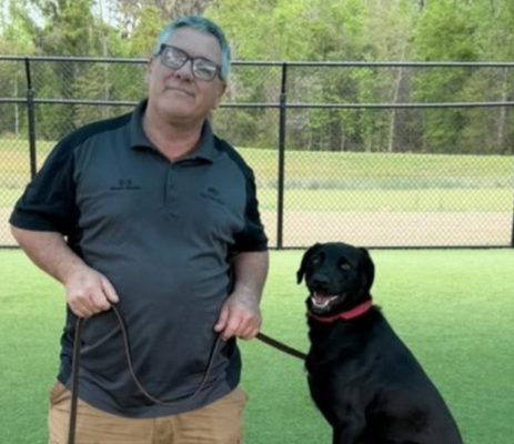 a man with blue hair and a black dog
