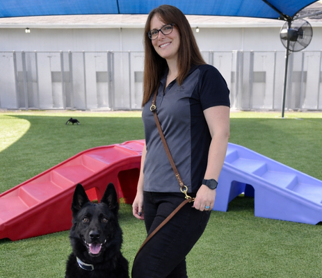 a woman standing next to a dog