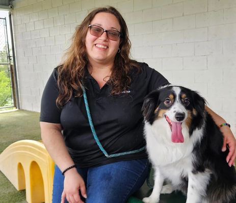a woman sitting next to a dog