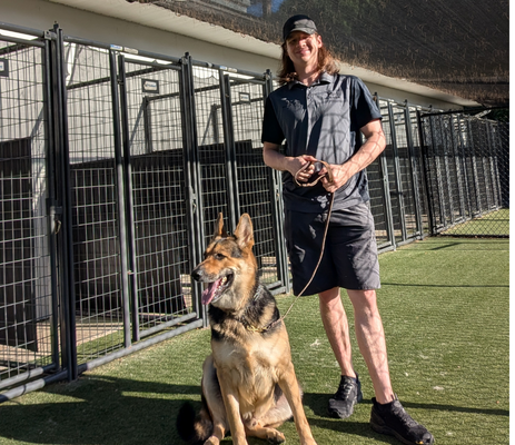 a man standing next to a dog