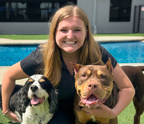 a woman holding two dogs