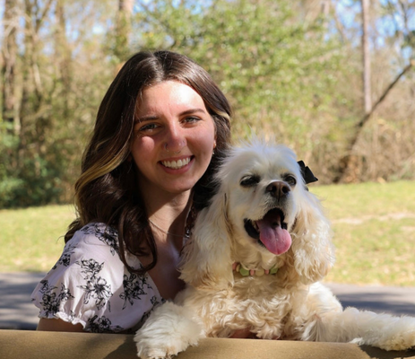 a woman smiling with a dog
