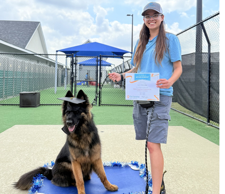 a woman holding a diploma and a dog