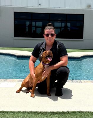 a woman holding a dog by a pool