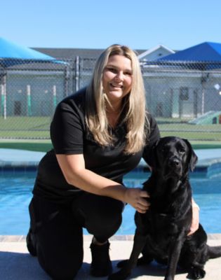 a woman kneeling next to a dog