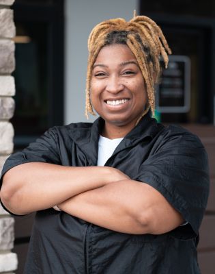 a woman with blonde dreadlocks smiling
