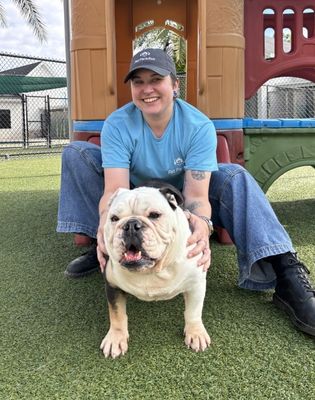 a woman sitting on grass with a dog