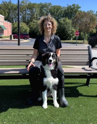 a woman sitting on a bench with a dog
