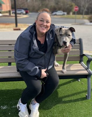 a woman sitting on a bench with a dog