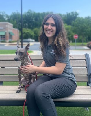 a woman sitting on a bench holding a dog