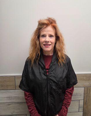 a woman with red hair and a black jacket