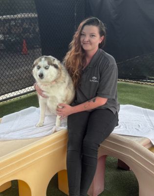 a woman sitting on a table with a dog