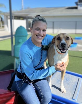 a woman sitting on a trampoline with a dog