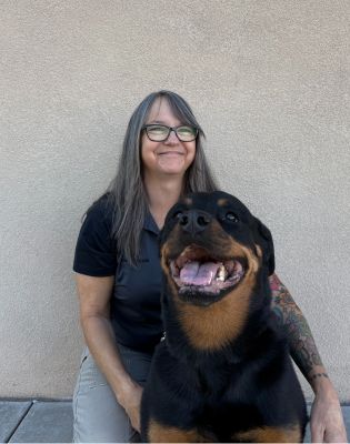 a woman smiling with a dog