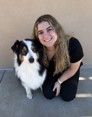 a woman sitting next to a dog