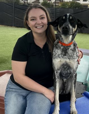 a woman sitting on a bed with a dog