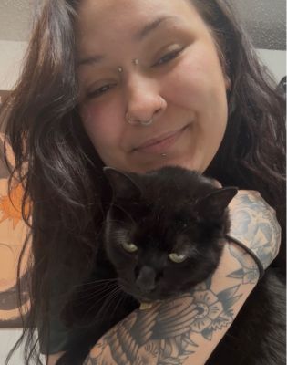 a woman with tattoos holding a cat