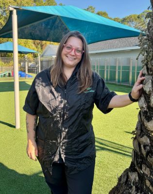 a woman standing next to a tree