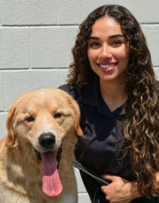 a woman with long curly hair and a dog