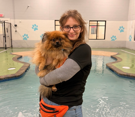 a woman holding a dog in a pool