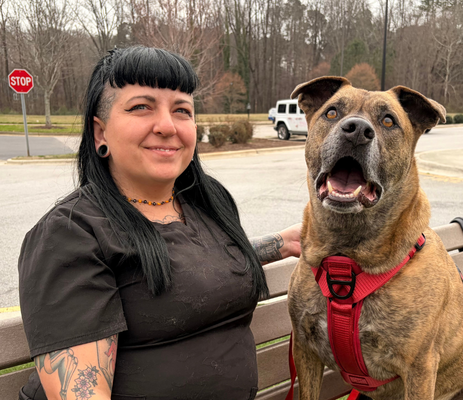 a woman sitting on a bench with a dog